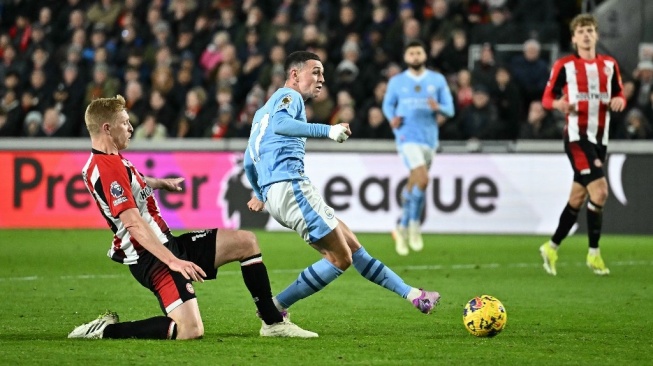 Gelandang Manchester City, Phil Foden mencetak gol ketiga timnya selama pertandingan pekan ke-23 Liga Inggris 2023-2024 antara Brentford vs Manchester City di Stadion Komunitas Gtech di London pada 5 Februari 2024.Ben Stansall / AFP.