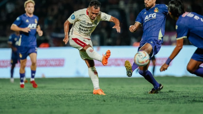 Winger Bali United, Irfan Jaya (tengah) melepaskan tendangan ketika mendapat kawalan dari para pemain Persik Kediri dalam laga pekan ke-24 Liga 1 2023-2024 di Stadion Brawijaya, Kediri, Senin (5/2/2024) malam WIB. [Dok. Bali United]