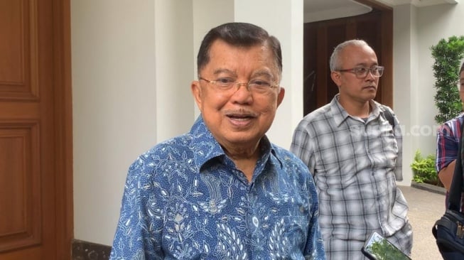 Wakil Presiden RI ke-10 dan ke-12, Jusuf Kalla atau JK, menilai pembagian bantuan sosial atau bansos di pinggir jalan dan di pasar melanggar aturan. (Suara.com/Rakha)