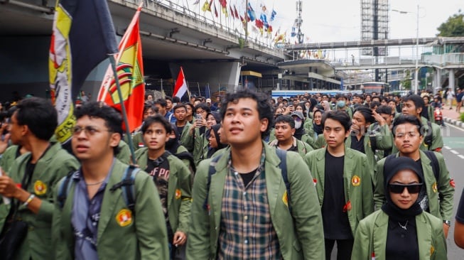 Sejumlah mahasiswa dari berbagai kampus melakukan aksi long march menuju Istana Negara saat menggelar unjuk rasa di Kawasan Grogol, Jakarta, Rabu (7/2/2024). [Suara.com/Alfian Winanto]