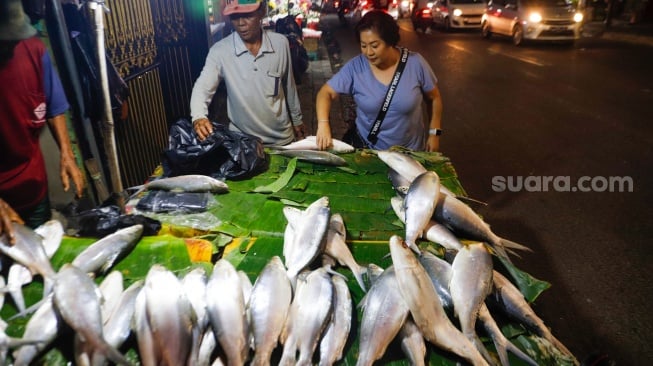 Warga membeli ikan Bandeng di kawasan Rawa Belong, Jakarta, Kamis (8/2/2024). [Suara.com/Alfian Winanto]