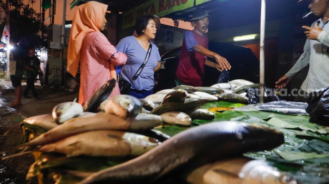 Warga membeli ikan Bandeng di kawasan Rawa Belong, Jakarta, Kamis (8/2/2024). [Suara.com/Alfian Winanto]