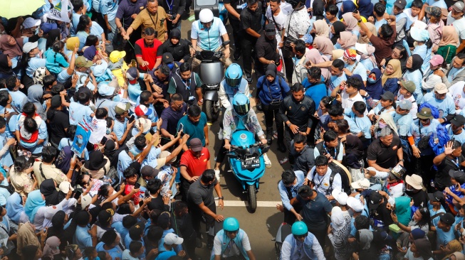 Calon Wakil Presiden (Cawapres) nomor urut 2, Gibran Rakabuming Raka bersama istrinya, Selvi Ananda (tengah) menaiki sepeda motor listrik saat menghadiri Kampanye Akbar di Stadiun Utama Gelora Bung Karno (SUGBK), Jakarta, Sabtu (10/2/2024). [Suara.com/Alfian Winanto]