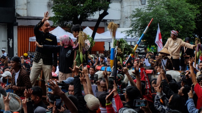 Pasangan capres dan cawapres nomor urut 3 Ganjar Pranowo (kiri) dan Mahfud MD (kanan) menaiki gerobak sapi saat kirab kampanye akbar di Solo, Jawa Tengah, Sabtu (10/2/2024). [ANTARAFOTO/Maulana Surya].