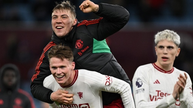 Gelandang Manchester United, Scott McTominay (kiri bawah) melakukan selebrasi usai kemenangan timnya atas Aston Villa pada laga Liga Inggris di Villa Park, Birmingham, Minggu (11/2/2024) malam WIB. [P Ellis / AFP]