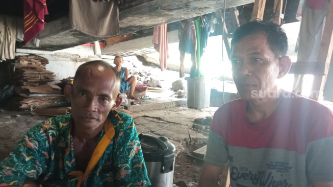 Surwadi (kiri) dan rekannya Herdi, pemulung yang tinggal di kolong jembatan kawasan Kuningan, Jakarta Selatan. (Suara.com/Muhamad Iqbal Fathurahman)