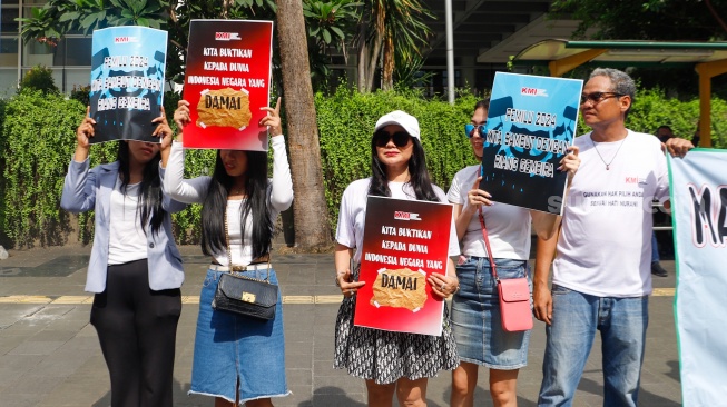 Sejumlah aktivis saat menggelar aksi di kawasan Bundaran Hotel Indonesia (HI), Jakarta, Selasa (13/2/2024). [Suara.com/Alfian Winanto]