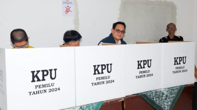 Plh Gubernur Jawa Timur Adhy Karyono (tiga kanan) saat memberikan hak suara Pemilu 2024 di TPS 37 Kelurahan Dr. Soetomo, Surabaya, Rabu (14/2/2024) [ANTARA/HO-Biro Adpim Jatim]