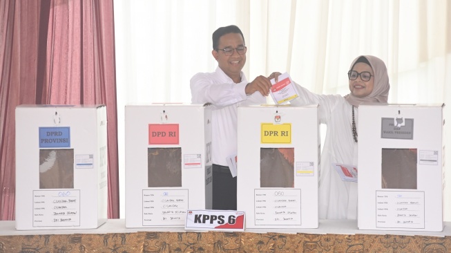 Capres nomor urut 1 Anies Baswedan (kiri) bersama istrinya Fery Farhati memasukkan surat suara Pemilu 2024 ke dalam kotak suara di TPS 60, Lebak Bulus, Jakarta, Rabu (14/2/2024). [ANTARA FOTO/Indrianto Eko Suwarso].