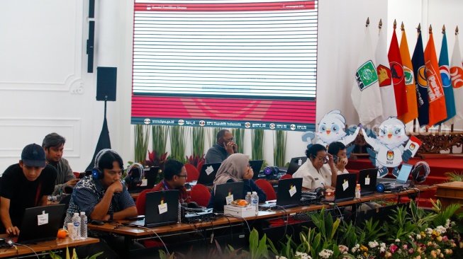 Petugas memantau hasil rekapitulasi sementara pemungutan suara Pemilihan Umum (Pemilu) 2024 di Gedung Komisi Pemilihan Umum (KPU) Republik Indonesia di Jakarta, Kamis (15/2/2024). [Suara.com/Alfian Winanto]