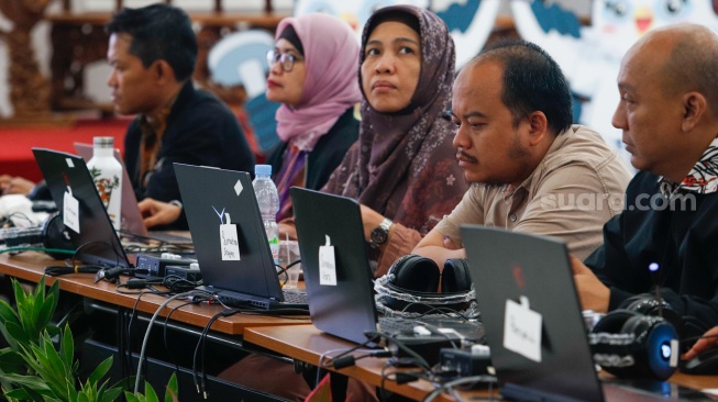 Petugas memantau hasil rekapitulasi sementara pemungutan suara Pemilihan Umum (Pemilu) 2024 di Gedung Komisi Pemilihan Umum (KPU) Republik Indonesia di Jakarta, Kamis (15/2/2024). [Suara.com/Alfian Winanto]