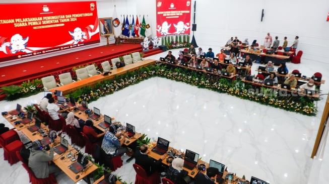 Petugas memantau hasil rekapitulasi sementara pemungutan suara Pemilihan Umum (Pemilu) 2024 di Gedung Komisi Pemilihan Umum (KPU) Republik Indonesia di Jakarta, Kamis (15/2/2024). [Suara.com/Alfian Winanto]