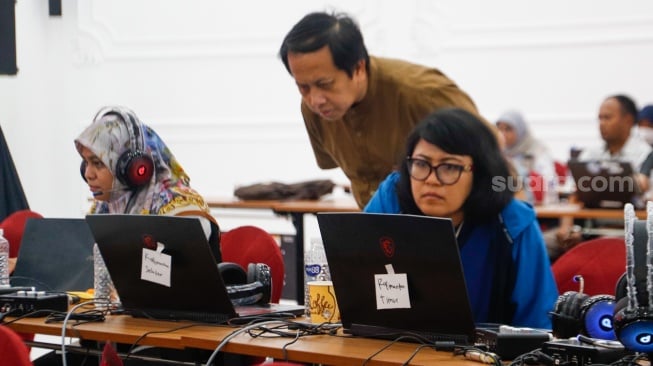 Petugas memantau hasil rekapitulasi sementara pemungutan suara Pemilihan Umum (Pemilu) 2024 di Gedung Komisi Pemilihan Umum (KPU) Republik Indonesia di Jakarta, Kamis (15/2/2024). [Suara.com/Alfian Winanto]