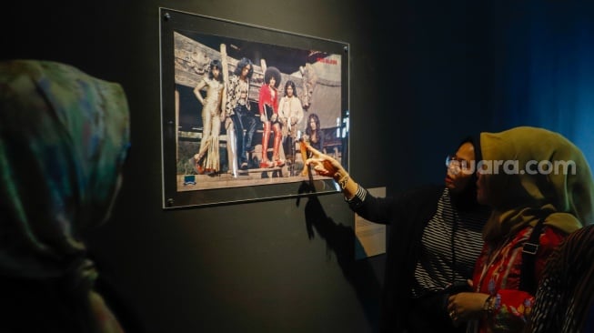 Pengunjung saat melihat Pameran Retrospektif 50 Tahun God Bless di Galeri Nasional, Jakarta, Jumat (16/2/2024). [Suara.com/Alfian Winanto]