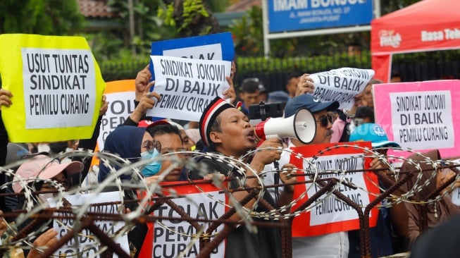 Massa dari Masyarakat Sipil Peduli Pemilu dan Demokrasi saat menggelar demo di depan Gedung Komisi Pemilihan Umum (KPU) RI, Jakarta, Jumat (16/2/2024). [Suara.com/Alfian Winanto]