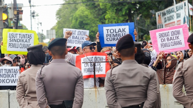 Massa dari Masyarakat Sipil Peduli Pemilu dan Demokrasi saat menggelar demo di depan Gedung Komisi Pemilihan Umum (KPU) RI, Jakarta, Jumat (16/2/2024). [Suara.com/Alfian Winanto]