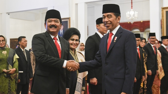 Presiden Joko Widodo (kanan) mengucapakan selamat kepada Menko Polhukam Hadi Tjahjanto usai pelantikan di Istana Negara, Jakarta, Rabu (21/2/2024). [ANTARA FOTO/Hafidz Mubarak A].