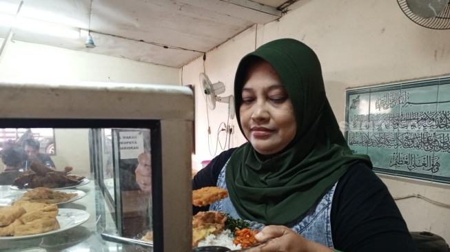 Tuti, pemilik warung nasi di Jakarta Barat menjerit karena sejumlah harga pangan termasuk beras naik (Suara.com/Faqih)