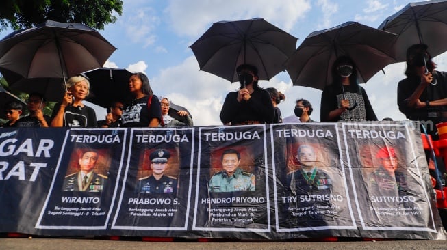 Sejumlah aktivis, akademisi, mahasiswa, dan elemen masyarakat sipil mengikuti Aksi Kamisan ke-806 di seberang Istana Merdeka, Jakarta, Kamis (22/2/2024). [Suara.com/Alfian Winanto]