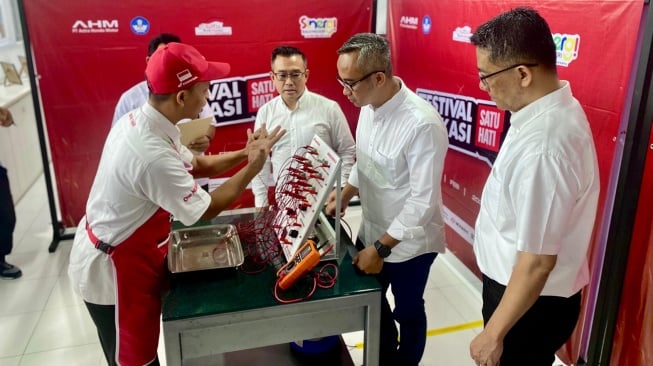 Marketing Director AHM Octavianus Dwi bersama General Manager Corporate Communication AHM Ahmad Muhibbuddin dan General Manager Technical Service AHM V.H. Kunsala Krishna sedang mendengarkan penjelasan salah satu peserta Festival Vokasi Satu Hati 2024 pada uji praktik elektrikal [PT Astra Honda Motor].