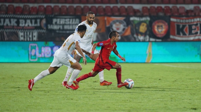 Pemain Persija Riko Simanjuntak saat berduel dengan dua penggawa Madura United saat kedua tim berhadapan di Liga 1 2023/2024 di Stadion Kapten I Wayan Dipta, Gianyar, Bali, Kamis (22/2/2024). (Dok. Persija).