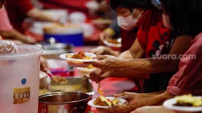 Warga keturunan Tionghoa mengambil makanan khas Lontong Cap Go Meh saat perayaan di Vihara Amurva Bhumi, Jakarta, Jumat (23/2/2024). [Suara.com/Alfian Winanto]