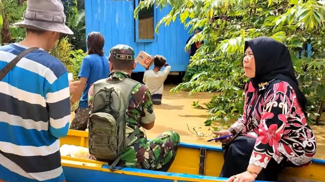 Banjir di Kelurahan Pemaluan. Lurah Ari Rahayu saat terjun membantu warganya. [Ist]