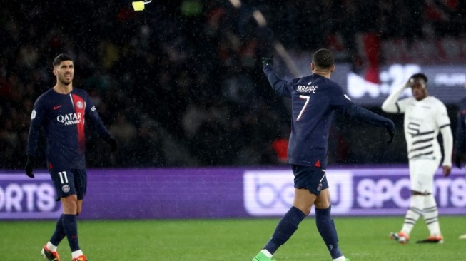 Paris Saint-Germain striker Kylian Mbappe (right) throws the team captain's ribbon to Paris Saint-Germain defender Achraf Hakimi as he leaves the field after being pulled off during Rennes' match against PSD at the Parc des Princes Stadium, Paris, France, on February 25, 2024. (AFP/FRANCK FIFE)