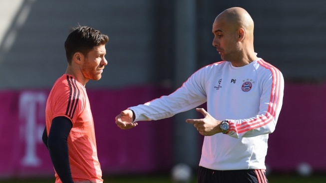 Pelatih kepala Bayern Munich asal Spanyol Pep Guardiola (kanan) berbicara dengan gelandang Spanyol Bayern Munich Xabi Alonso (kiri) selama sesi latihan tim terakhir satu hari sebelum babak 16 besar Liga Champions, pertandingan leg pertama antara Juventus Turin dan Bayern Munich di lapangan latihan di Munich, Jerman selatan, pada 22 Februari 2016.CHRISTOF STACHE / AFP