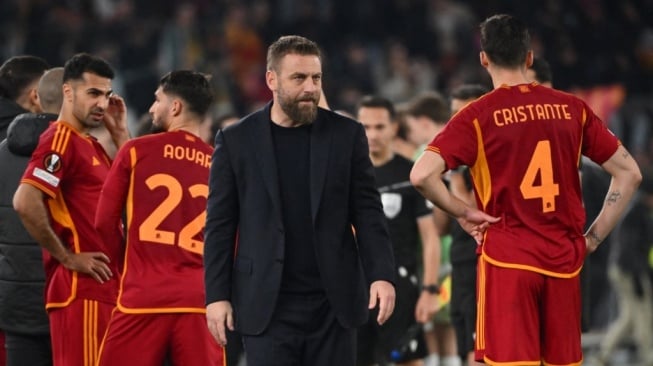 Pelatih AS Roma asal Italia, Daniele De Rossi berdiri bersama para pemain sebelum adu penalti selama pertandingan play-off babak 16 besar Liga Eropa 2023-2024 antara AS Roma vs Feyenoord di stadion Olimpiade di Roma pada 22 Februari 2024.Alberto PIZZOLI / AFP.