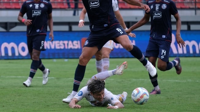 Pesepak bola Persija Jakarta Ryo Matsumura (bawah) terjatuh saat berebut bola dengan pesepak bola Arema FC Julian Guevara (atas) pada pertandingan BRI Liga 1 di Stadion Kapten I Wayan Dipta, Gianyar, Bali, Senin (26/2/2024). Arema FC mengalahkan Persija Jakarta dengan skor 3-2. ANTARA FOTO/Nyoman Hendra Wibowo/nz