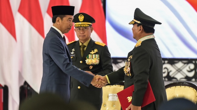 Presiden Joko Widodo (kiri) berjabat tangan dengan Menteri Pertahanan Prabowo Subianto (kanan) disaksikan Panglima TNI Jenderal TNI Agus Subianto (tengah) usai menyematkan pangkat Jenderal TNI Kehormatan dalam Rapat Pimpinan (Rapim) TNI dan Polri Tahun 2024 di Mabes TNI, Jakarta, Rabu (28/2/2024). [ANTARA FOTO/Bayu Pratama S].