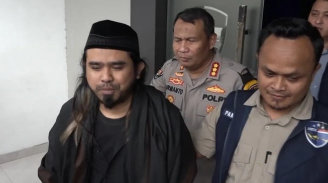 Polisi membawa Gus Samsudin untuk diperiksa di Polda Jatim, Kamis (29/2/2024) terkait pembuatan konten "tukar pasangan" suami istri yang videonya viral beberapa waktu lalu. ANTARA/HO-Bidhumas Polda Jatim