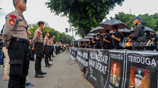 Sejumlah aktivis, akademisi, mahasiswa, dan elemen masyarakat sipil mengikuti Aksi Kamisan ke-807 di seberang Istana Merdeka, Jakarta, Kamis (29/2/2024). [Suara.com/Alfian Winanto]