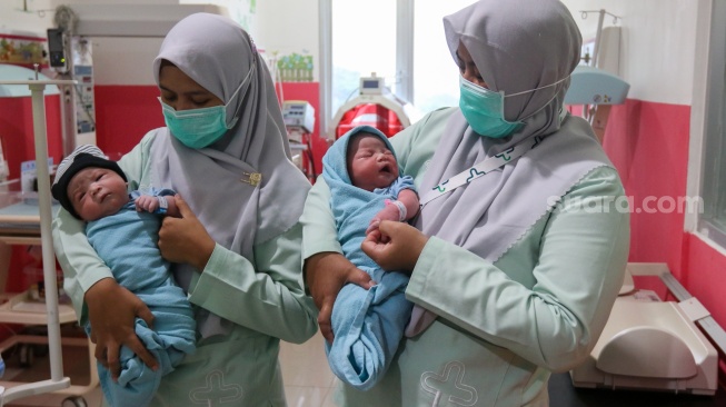 Petugas kesehatan merawat bayi yang baru lahir di RSUD Kramat Jati, Jakarta, Kamis (29/2/2024). [Suara.com/Alfian Winanto]