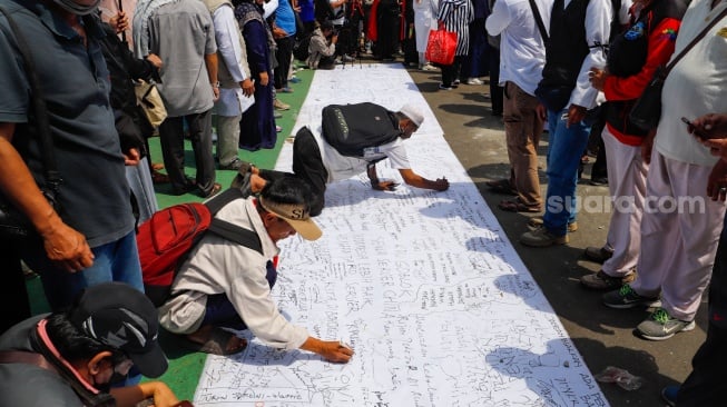 Massa dari sejumlah elemen masyarakat menuliskan tanda tangan ketika unjuk rasa saat


 Aksi Gema 0103 di Depan Gedung DPR RI, Jakarta, Jumat (1/3/2024). [Suara.com/Alfian Winanto]