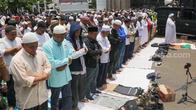 Massa dari sejumlah aliansi masyarakat menggelar salat jumat bersama saat Aksi Gema 0103 di Depan Gedung DPR RI, Jakarta, Jumat (1/3/2024). [Suara.com/Alfian Winanto]