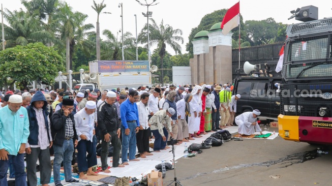 Massa dari sejumlah aliansi masyarakat menggelar salat jumat bersama saat Aksi Gema 0103 di Depan Gedung DPR RI, Jakarta, Jumat (1/3/2024). [Suara.com/Alfian Winanto]