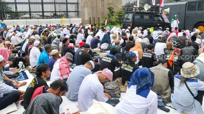 Massa dari sejumlah aliansi masyarakat menggelar salat jumat bersama saat Aksi Gema 0103 di Depan Gedung DPR RI, Jakarta, Jumat (1/3/2024). [Suara.com/Alfian Winanto]