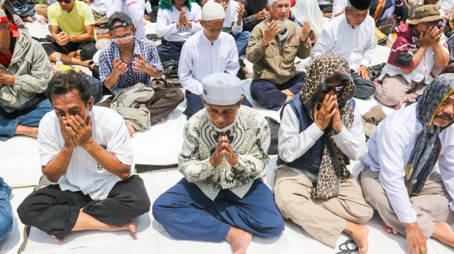 Massa dari sejumlah aliansi masyarakat menggelar salat jumat bersama saat Aksi Gema 0103 di Depan Gedung DPR RI, Jakarta, Jumat (1/3/2024). [Suara.com/Alfian Winanto]