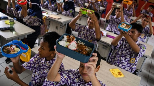 Sejumlah siswa menunjukkan makanan gratis saat simulasi program makan siang gratis di SMP Negeri 2 Curug, Kabupaten Tangerang, Banten, Kamis (29/2/2024). (ANTARA FOTO/Sulthony Hasanuddin)