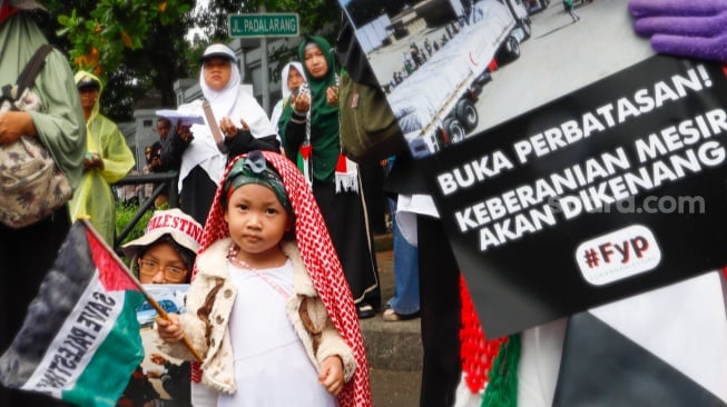 Massa mengangkat poster berisi tuntutan saat menggelar Aksi Bela Palestina di depan Kedutaan Besar Mesir, Jakarta, Senin (4/3/2024). [Suara.com/Alfian Winanto]
