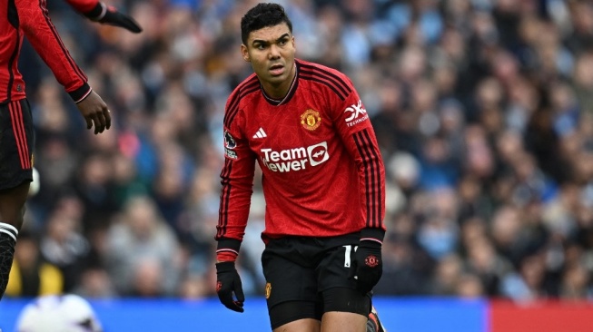 Gelandang Manchester United, Casemiro berlutut pada laga Liga Inggris melawan Manchester City di Stadion Etihad, Manchester yang rampung Senin (4/3/2024) dini hari WIB. [Paul ELLIS / AFP]