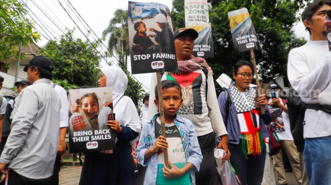 Massa mengangkat poster berisi tuntutan saat menggelar Aksi Bela Palestina di depan Kedutaan Besar Mesir, Jakarta, Senin (4/3/2024). [Suara.com/Alfian Winanto]
