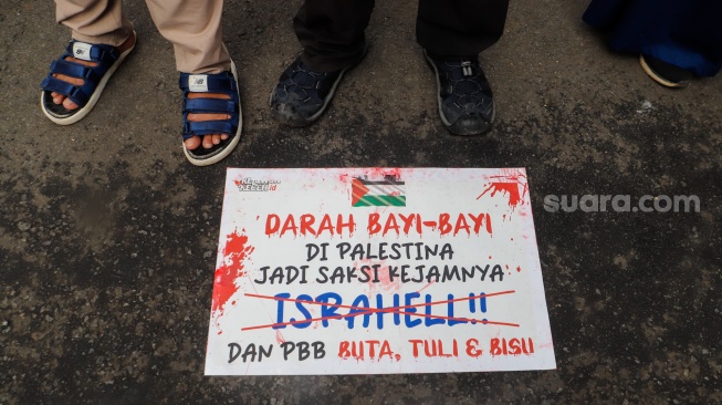 Salah satu poster berisi tuntutan saat Aksi Bela Palestina di depan Kedutaan Besar Mesir, Jakarta, Senin (4/3/2024). [Suara.com/Alfian Winanto]
