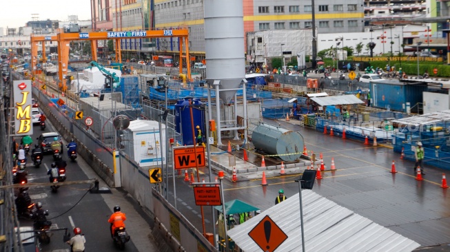 Pekerja beraktivitas di area proyek pembangunan MRT Fase 2A di Jalan Gajah Mada, Jakarta, Senin (4/3/2024). [Suara.com/Alfian Winanto]