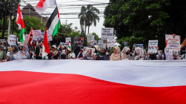 Massa mengangkat poster berisi tuntutan saat menggelar Aksi Bela Palestina di depan Kedutaan Besar Mesir, Jakarta, Senin (4/3/2024). [Suara.com/Alfian Winanto]
