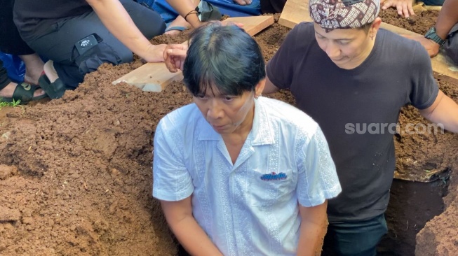 Bimbim Slank turun ke liang lahad di pemakaman sang ayah, Sidharta Manghurudin Soemarno di TPU Karet Bivak, Jakarta Pusat, Senin (5/3/2024). [Adiyoga Priyambodo/Suara.com]