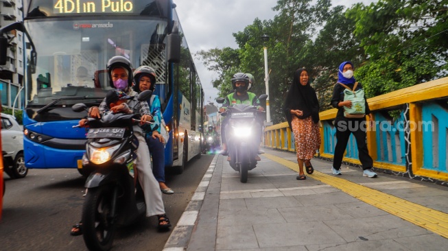 Pengendara sepeda motor melintas di trotoar kawasan Matraman, Jakarta, Selasa (5/3/2024). [Suara.com/Alfian Winanto]