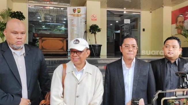 Rektor Universitas Pancasila (UP) Edie Toet Hendratno (topi putih) usai diperiksa sebagai terlapor terkait kasus dugaan pelecehan seksual di Polda Metro Jaya. (Suara.com/M Yasir)
